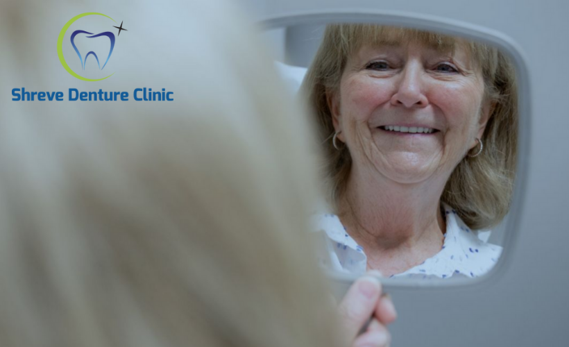 Woman checking her denture through the mirror.